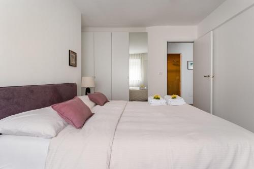 a large white bed with two pillows on it at Heart Apartment in Merano