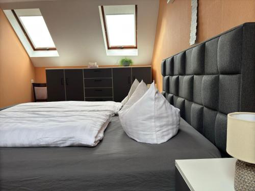 a bedroom with a bed with white sheets and two pillows at Pension Bergstube in Bad Langensalza