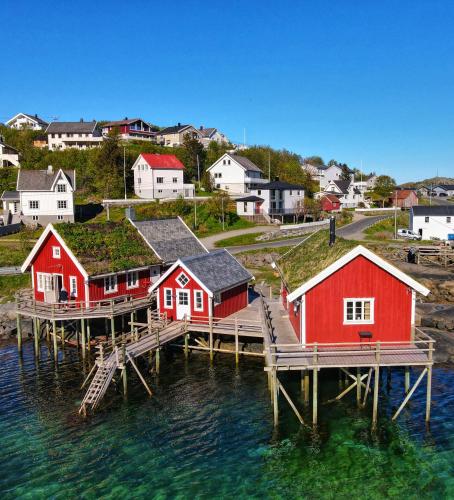 a group of houses on a dock in the water at Valen Cabins in Reine in Reine
