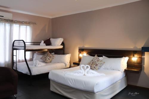 a bedroom with two beds with white towels on them at The Ultimate Lodge in Louis Trichardt