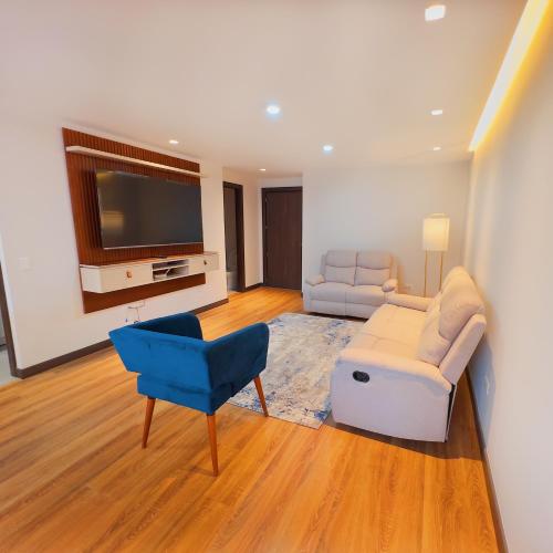a living room with a couch and a tv at Torre Gante Departamento de Lujo in Quito
