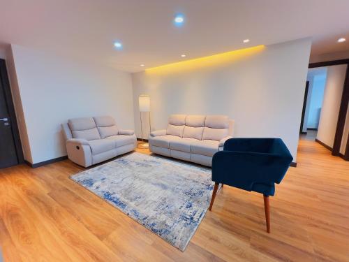 a living room with two couches and a rug at Torre Gante Departamento de Lujo in Quito