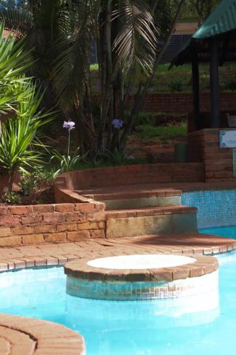 a swimming pool with steps next to a resort at The Ultimate Lodge in Louis Trichardt