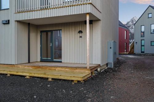 a house with a wooden deck on the side of it at Rorbuleilighet i idylliske Henningsvær in Henningsvær
