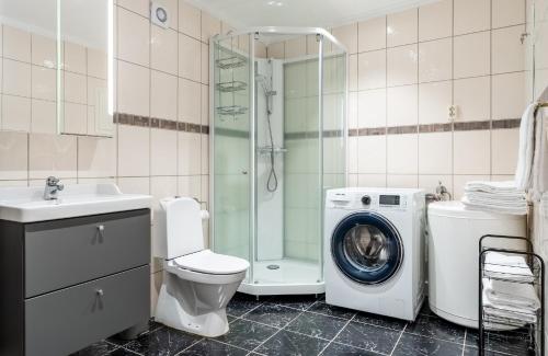 a bathroom with a toilet a sink and a washing machine at Northstay - City Square in Tromsø