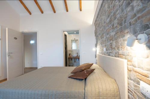 a bedroom with a bed and a brick wall at Amiata Romantica in Bagnolo