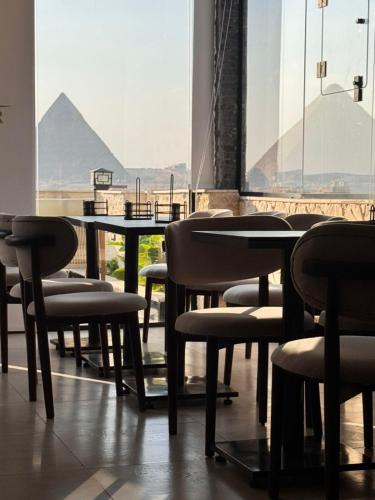 a group of chairs and tables in a room with a pyramid at Rixoss Tower Pyramids View in Cairo