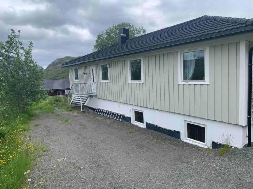 a house with a bench on the side of it at Leilighet med balkong og havutsikt på Napp. in Napp