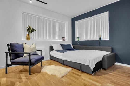 a bedroom with a bed and a chair at Northstay - The Urban City Haven in Tromsø