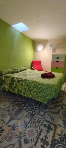 a bedroom with a green bed with a red pillow at Casa Mamre in Maspalomas