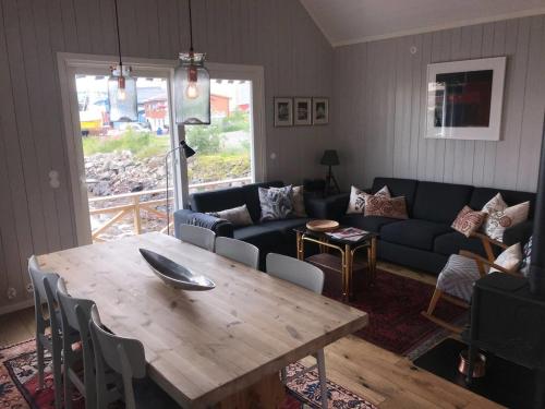 a living room with a table and a couch at Nora's Waterfront Cabin in Svolvær
