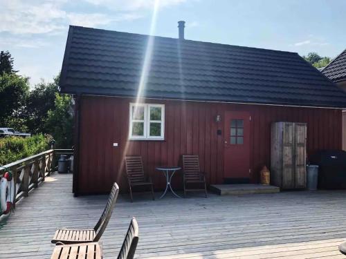 a red building with chairs and a table on a deck at Nora's Waterfront Cabin in Svolvær