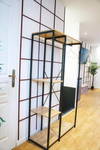 a bookcase with wooden shelves in a room at Capstay Point central ch3 - Netflix in Tourcoing