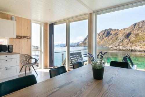 a kitchen with a table with a view of the water at Lofoten Waterfront luxury lodge in Ballstad