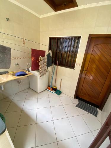 a bathroom with a toilet and a sink and a door at Casa na Praia Bertioga in Bertioga