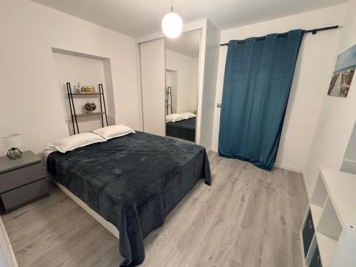 a bedroom with a bed and a blue curtain at LOV - Lombadinha Ocean View in Gaula
