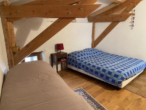 une chambre avec un lit dans une pièce avec des plafonds en bois dans l'établissement La Pauze - Gîte familial au bord de l'Allier - Family Cottage by Allier Riverside, à Villeneuve-dʼAllier