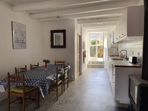 une cuisine avec une table et des chaises ainsi qu'une cuisine avec une table et un comptoir dans l'établissement La Pauze - Gîte familial au bord de l'Allier - Family Cottage by Allier Riverside, à Villeneuve-dʼAllier
