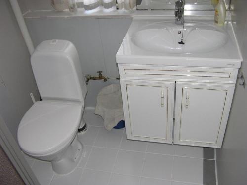 un bagno bianco con un water e un lavandino di Nydelig leilighet i første etage. a Sund