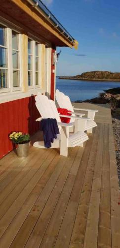 a deck with two white chairs on a house at Valberg High Quality Seaview Cabin in Valberg