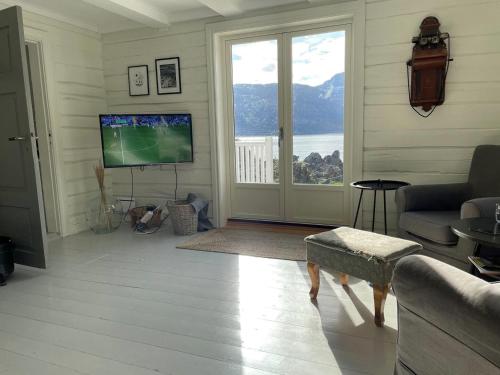 GravdalにあるVettingstua, beautiful house down by the sea.のリビングルーム(テレビ、大きな窓付)