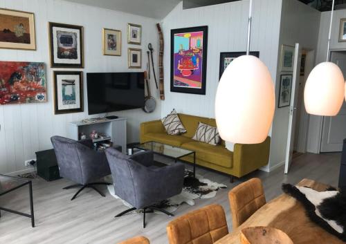 a living room with a couch and a tv at Amazing waterfront rorbu (free car-charging) in Stamsund