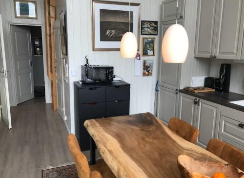 a kitchen with a wooden table and a kitchen counters at Amazing waterfront rorbu (free car-charging) in Stamsund