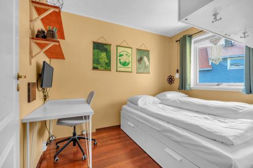 une chambre avec deux lits et un bureau et une fenêtre dans l'établissement Cosy top-floor apartment, à Tomasjorda