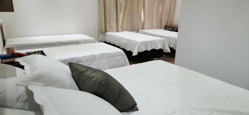 a room with three beds and a couch at Pousada Araúna Angra in Angra dos Reis