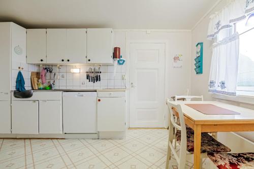 SennesvikにあるNorheim, Nordlandshus i fredelig vikの白い冷蔵庫とテーブルのあるキッチン