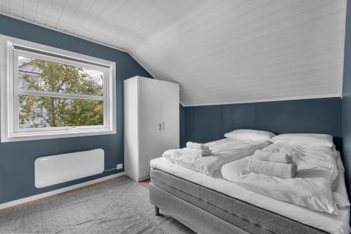 a bedroom with a large bed and a window at Northstay - Grimsby House in Tromsø
