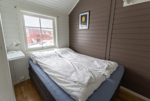 a bed in a room with a window at Authentic Lofoten Rorbu in Stamsund