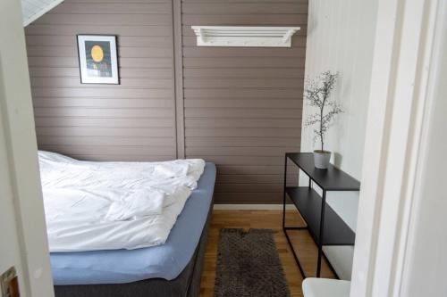 a small bedroom with a bed and a table at Authentic Lofoten Rorbu in Stamsund