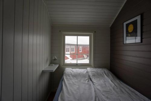 a small room with a bed and a window at Authentic Lofoten Rorbu in Stamsund