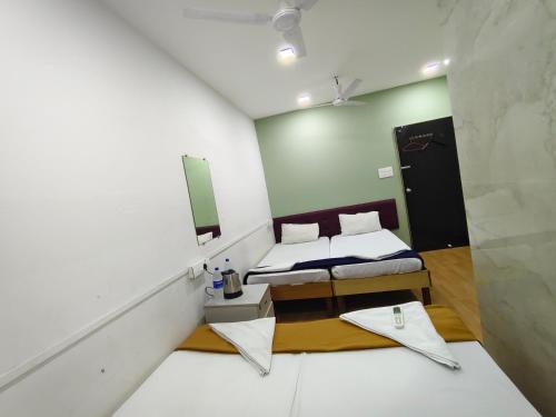 a small room with two beds and a mirror at Hotel CASABA Nine in Mumbai