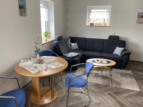a living room with a couch and a table and chairs at Ferienwohnung Familie Schleicher in Nordheim vor der Rhön