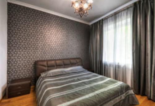 a bedroom with a bed and a chandelier at Готель-ресторан Chalet in Bila Tserkva