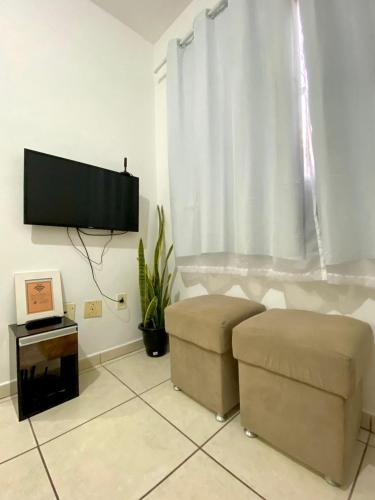 ein Wohnzimmer mit Flachbildfernseher und Couch in der Unterkunft Ap da Thay - Os tropeiros in Campina Grande