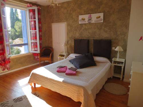 - une chambre avec un lit et 2 serviettes roses dans l'établissement DOMAINE DU SIESTOU WINE RESORT & spa, à Laure-Minervois