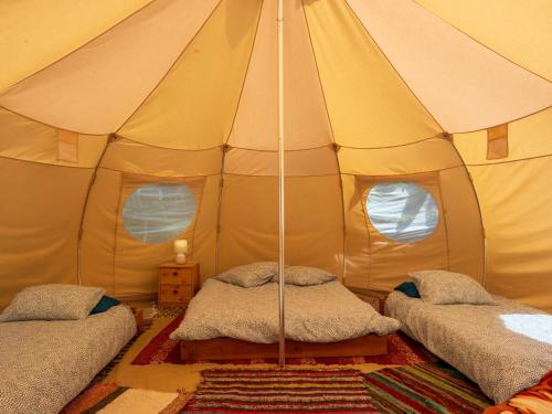 une chambre avec deux lits dans une tente dans l'établissement Horizons Verts Luna Tent, à Puivert