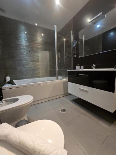 a bathroom with a toilet and a sink and a tub at AL Manas Pereira in Castro Marim