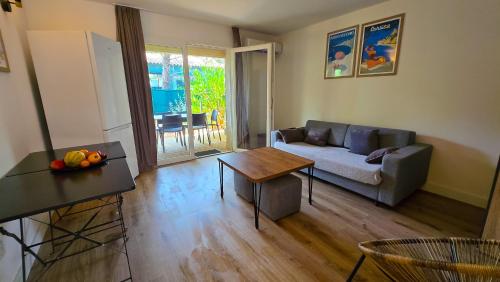a living room with a couch and a table at Fiori Di Cala Rossa, Établissement CARDOGA Piscine, Mer & Montagne in Lecci