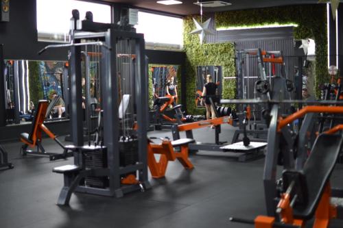 a gym with several tread machines and a man in the background at Hotel Pamela Concept in Negotino
