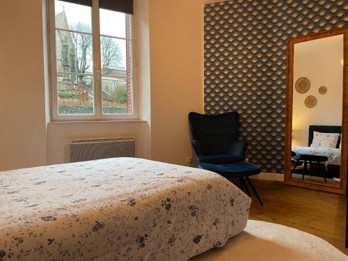 une chambre avec un lit, une chaise et une fenêtre dans l'établissement Petite maison au cœur de la ville, à Pouzauges