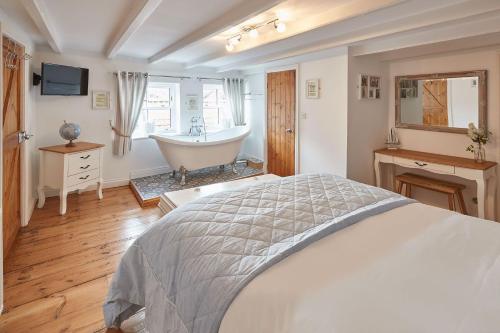 a bedroom with a bed and a bath tub at Sanders House in Whitby