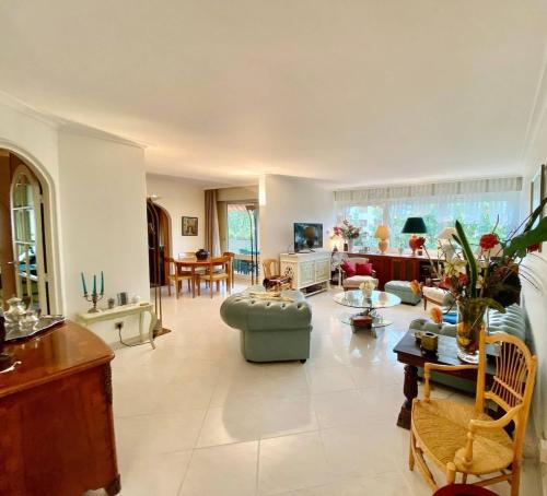 un grand salon avec un canapé et une table dans l'établissement Appartement T3 bis aux portes de Genève, à Annemasse