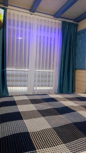a bedroom with a checkered floor and a window at Садиба "Ековид" in Krivorovnya