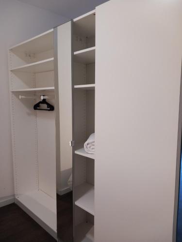 a white closet with white shelves and a door at Charming Retreat Apartment City 20Alpha in Delft