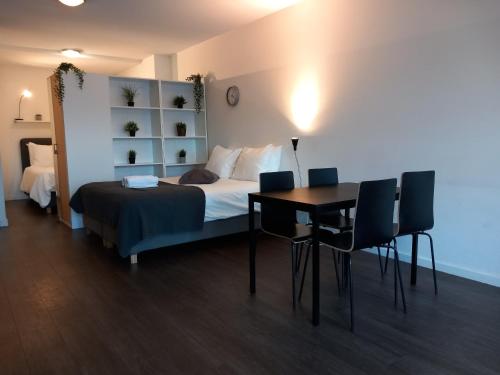 a bedroom with a bed and a table and chairs at Charming Retreat Apartment City 20Alpha in Delft