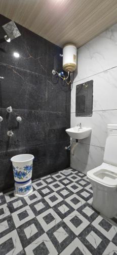 un bagno bianco e nero con servizi igienici e lavandino di Shivnandani a Ujjain